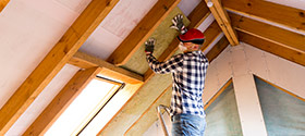 Image of a contractor installing insulation in an attic.