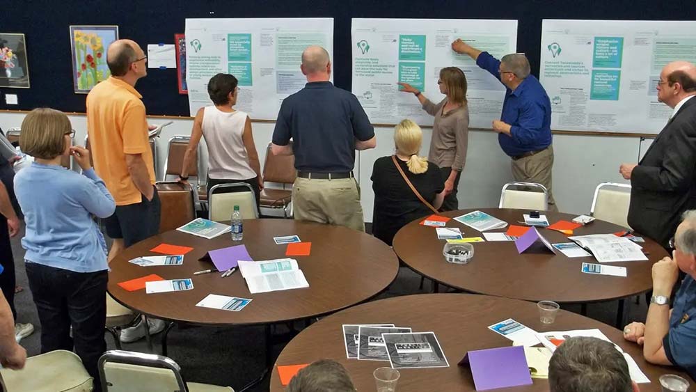 Community members collaborating around whiteboard